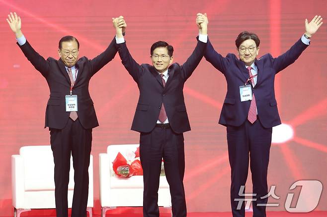 제21대 대통령선거 국민의힘 후보자로 선출된 김문수 후보가 3일 경기 고양시 킨텍스에서 열린 5차 전당대회에서 권영세 비상대책위원장, 권성동 원내대표와 손을 맞잡아 들어보이고 있다. 2025.5.3/뉴스1 ⓒ News1 이광호 기자