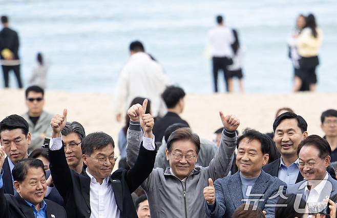 '골목골목 경청투어 : 동해안벨트편'에 나선 이재명 더불어민주당 대통령 후보가 3일 오후 강원 강릉시 안목해변에서 관계자들과 손을 들어보이고 있다. 2025.5.3/뉴스1 ⓒ News1 이재명 기자