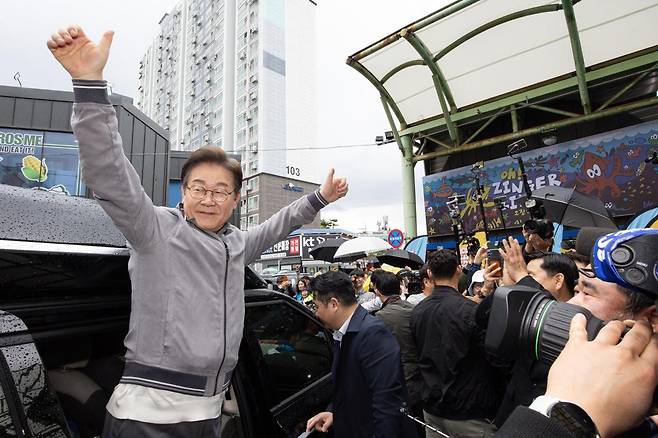 더불어민주당 이재명 대선 후보가 3일 오전 강원 속초시 중앙로 속초관광수산시장에서 시민들과 인사를 나눈 후 차량에 탑승해 인사하고 있다. 뉴스1
