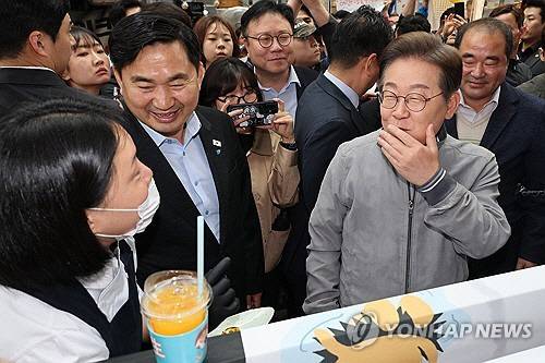 이재명 더불어민주당 대선 후보가 '골목골목 경청투어' 사흘째인 3일 '동해안벨트' 첫 방문지인 강원도 속초시 중앙재래시장에서 청년 상인들이 만든 '성게 초콜릿'을 맛보고 있다.   [연합뉴스]