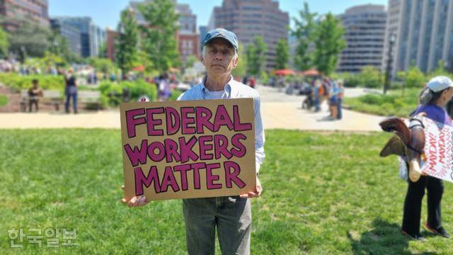 국제 노동절인 1일 미국 워싱턴 백악관 북동쪽 프랭클린공원 집회에 참여한 데니스 로빈이 “연방정부 노동자들도 중요하다” 손팻말을 들고 있다. 워싱턴=권경성 특파원