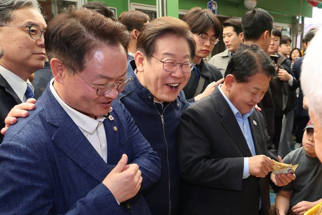 ▲ 더불어민주당 이재명 대선 후보가 ‘골목골목 경청투어’ 접경지역 방문 이틀째인 2일 강원도 인제군 원통전통시장에서 건어물 가게에 들러 황태채를 맛본 뒤 김병주·허영 의원에게 구입을 권하고 있다. 출처=연합뉴스