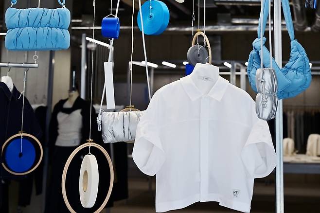 폐옷과 폐어망에서 나온 플라스틱 조각들을 녹여 실로 뽑아내 재활용한 가방이 걸려 있다. 사진=이승재 기자