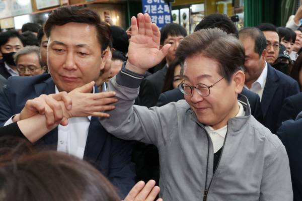 더불어민주당 이재명 대선 후보가 ‘골목골목 경청투어’ 사흘째인 3일 강원도 양양군 양양시장에서 도민들과 악수 등 접촉을 피하며 인사를 나누고 있다.  연합뉴스