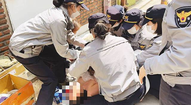 경찰이 지난달 17일 서울북부지법의 명도집행 당시 쓰러져 있는 김모씨 건강 상태를 살피는 모습.    미아리 성 노동자 이주대책위원회 제공