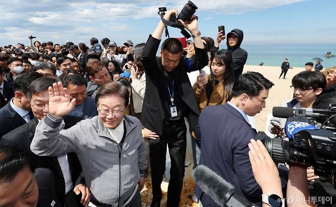 [강릉=뉴시스] 조성우 기자 = 민심을 청취하는 '경청 투어'에 나선 이재명 더불어민주당 대선후보가 3일 강원도 강릉시 안목해변 카페거리를 걸으며 주민들과 관광객들에게 인사하고 있다. 2025.05.03. xconfind@newsis.com /사진=조성우