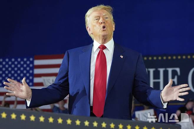 [워런(미시간주)=AP/뉴시스] 사진은 도널드 트럼프 미국 대통령이 지난달 29일(현지 시간) 미시간주 워런의 머콤 카운티 커뮤니티 컬리지 스포츠 엑스포 센터에서 취임 100일 기념 집회를 열고 지지자들의 환호에 포즈를 취하고 있는 모습. 2025.04.30.