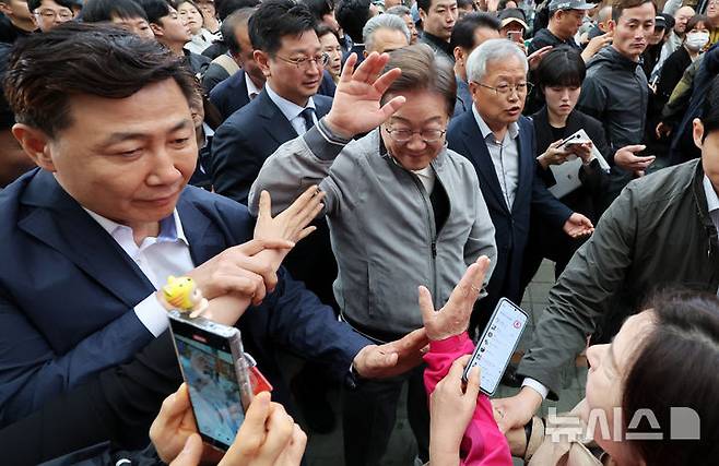 [양양=뉴시스] 조성우 기자 = 민심을 청취하는 '경청 투어'에 나선 이재명 더불어민주당 대선후보가 3일 강원도 양양군 양양시장에서 상인 및 주민들에게 인사를 하는 가운데 이 후보 경호원들 대인 직접 접촉을 차단하고 있다. 이 후보 측은 "후보에 대한 피습 모의 제보가 잇따르고 있다"고 밝혔다. 2025.05.03. xconfind@newsis.com