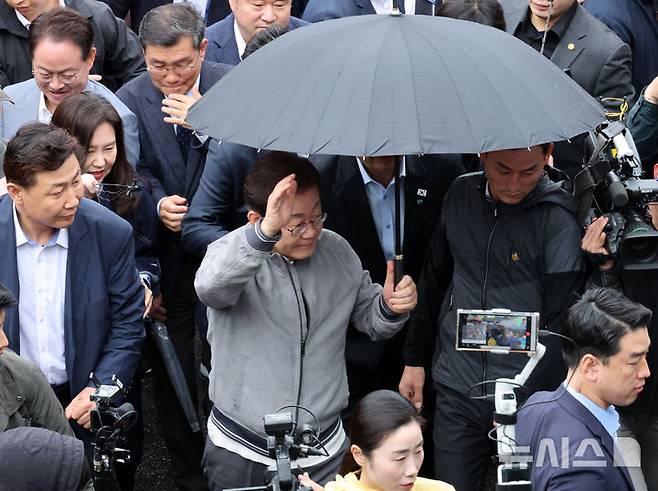 [속초=뉴시스] 조성우 기자 = 민심을 청취하는 '경청 투어'에 나선 이재명 더불어민주당 대선후보가 3일 강원도 속초시 속초중앙시장을 방문하기 위해 차에서 내려 경호를 받으며 이동하고 있다. 이 후보 측은 "후보에 대한 피습 모의 제보가 잇따르고 있다"고 밝혔다. 2025.05.03. xconfind@newsis.com