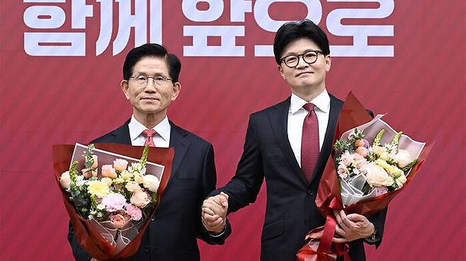 국민의힘 대선 최종 경선에 진출한 김문수(왼쪽)·한동훈 후보가 29일 서울 여의도 당사에서 3차 경선 결과 발표 후 꽃다발을 들고서 기념촬영 하고 있다. (사진=국회사진기자단, 연합뉴스)