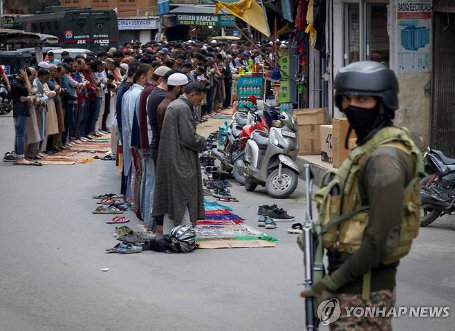 인도·파키스탄 갈등 2일 인도령 카슈미르 스리나가르에서 무슬림들이 거리에서 기도하는 가운데 무장한 군인이 경계를 서고 있다.
[로이터 연합뉴스 자료사진. 재판매 및 DB 금지]