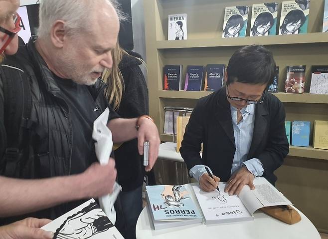 그림으로 서명하는 김금숙 작가 (부에노스아이레스=연합뉴스) 김선정 통신원 = 지난 1일(현지시간) 제49회 부에노스아이레스 국제도서박람회에서 그래픽노블 '풀'의 김금숙 작가가 독자의 책에 시그니처 그림으로 서명하고 있다. '풀'을 매우 감명 깊게 봤다는 디에고(60) 씨는 역사 교사로서 학생들에게 위안부 역사도 가르치고 있다고 연합뉴스에 말했다. 2025.5.3 sunniek8@yna.co.kr