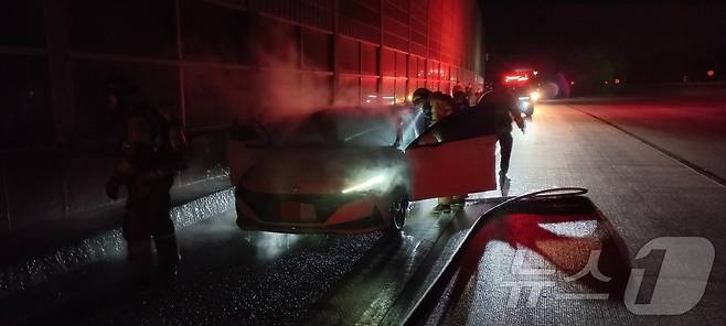 (구미=뉴스1) 김종엽 기자 = 4일 0시58분쯤 경북 구미시 원평동 경부고속도로 대구 방향 173.7㎞ 지점을 달리던 승용차에서 불이 나 소방대원이 진화를 하고 있다.(경북소방본부 제공. 재판매 및 DB 금지) 2025.5.4/뉴스1 ⓒ News1 김종엽 기자