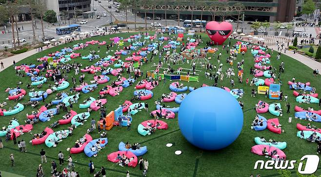 서울야외도서관 운영 첫 주말을 맞은 21일 오후 서울 중구 서울광장에 마련된 '책읽는 서울광장'을 찾은 시민들이 독서와 산책을 즐기고 있다.  2024.4.21/뉴스1 ⓒ News1 장수영 기자