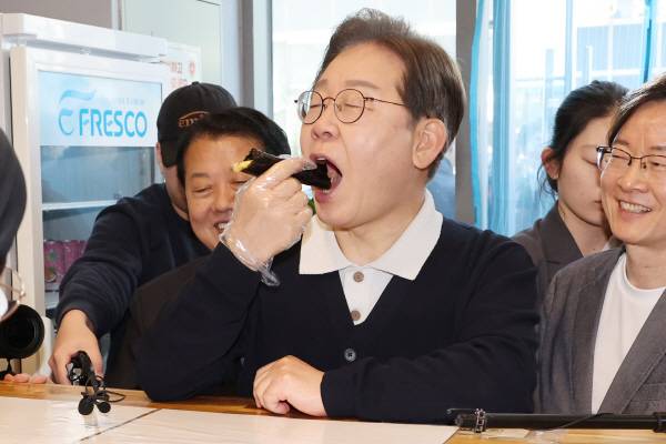 더불어민주당 이재명 대선 후보가 ‘골목골목 경청투어’ : 단양8경편‘에 나선 4일 경북 예천군 도청신도시에서 김밥집에 들러 상인과 대화를 하며 꼬마김밥을 사먹고 있다. 연합뉴스