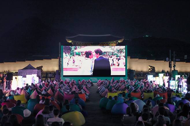 People watch a film at an outdoor library opened at Gwanghwamun Plaza in central Seoul in 2024. (Seoul Metropolitan Government)