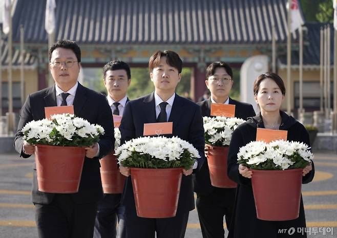 이준석 개혁신당 대통령 후보가 천하람, 이주영 선대위원장과 4일 광주 북구 국립 5·18 민주묘지를 참배하기 위해 국화꽃을 들고 있다. (이준석 캠프 제공, 재판매 및 DB 금지) 2025.5.4/사진=뉴스1 /사진=(광주=뉴스1)