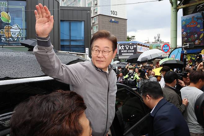 이재명 더불어민주당 대선 후보가 ‘골목골목 경청투어’ 사흘째인 3일 ‘동해안벨트’ 첫 방문지인 강원도 속초시 중앙재래시장에서 강원도민들을 만난 뒤 차에 올라 인사하고 있다. [연합]