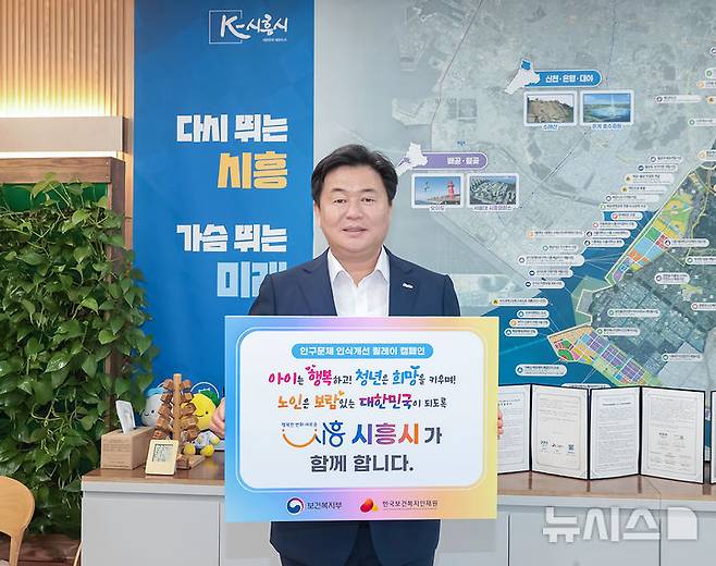 [시흥=뉴시스] 시흥시가 '인구문제 인식 개선 릴레이 캠페인'에 참여한 가운데 임병택 시장이 시를 대표해 홍보 피켓을 들고 행사에 참여하고 있다. (사진=시흥시 제공) 2025.05.04.  photo@newsis.com