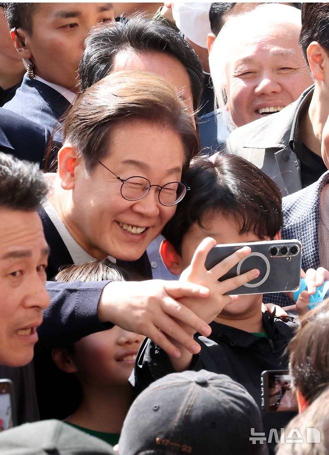 [영월=뉴시스] 조성봉 기자 = 민심을 청취하는 '경청 투어'에 나선 이재명 더불어민주당 대선후보가 4일 강원 영월서부시장에서 어린이와 셀카를 찍고 있다. 2025.05.04. suncho21@newsis.com