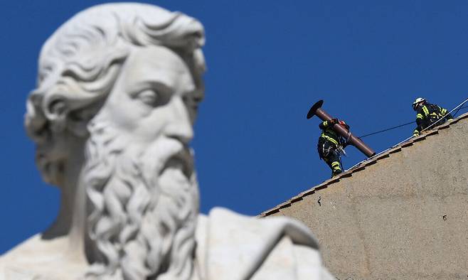 차기 교황 선출을 위한 준비작업으로 2일(현지시간)&nbsp;바티칸 시스티나 성당 지붕에 로마 소방관들이 굴뚝을 설치하고 있다. 바티칸=EPA·연합뉴스