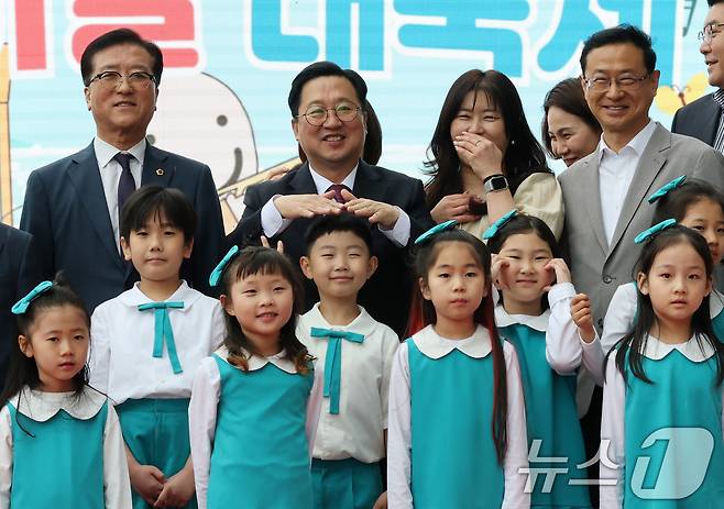 이장우 대전시장이 5일 대전 유성구 어린이회관에서 열린 제103주년 어린이날 기념행사에서 기념촬영에 앞서 비가 내리자 손으로 어린이 비를 막아주고 있다. 2025.5.5/뉴스1 ⓒ News1 김기태 기자