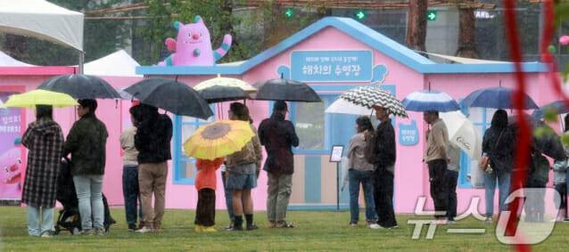 서울을 비롯한 수도권 일대에 비가 내린 1일 서울 중구 서울광장에서 우산을 쓴 시민들이 서울스프링페스타 부스 입장을 기다리고 있다. (사진=뉴스1)