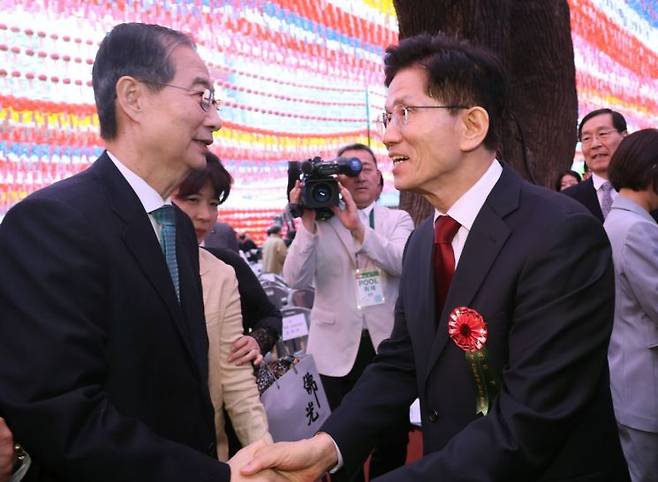 김문수 국민의힘 대선 후보(오른쪽)와 무소속 한덕수 대선 예비후보가 5일 서울 종로구 조계사에서 열린 불기 2569년 부처님오신날 봉축법요식을 마친 뒤 악수하고 있다. 연합뉴스