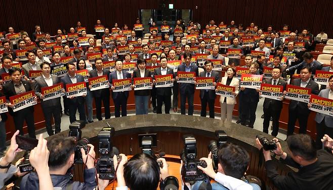 더불어민주당 박찬대 대표 직무대행 겸 원내대표와 의원들이 4일 서울 여의도 국회에서 열린 긴급 의원총회에서 피켓을 들고 구호를 외치고 있다. 2025.05.04. 서울=뉴시스