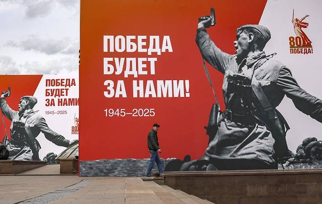 러시아 모스크바 시내 크렘린궁 근처에 설치된 2차 세계대전 전승절 80주년 기념 브로마이드 앞을 4일(현지시간) 한 남성이 지나가고 있다. EPA연합뉴스
