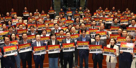 더불어민주당 박찬대 당 대표 직무대행 겸 원내대표(앞줄 가운데)와 의원들이 4일 국회 비상 의원총회에서 ‘대선개입 대법원 규탄!’이 적힌 피켓을 들고 구호를 외치고 있다. [뉴시스]