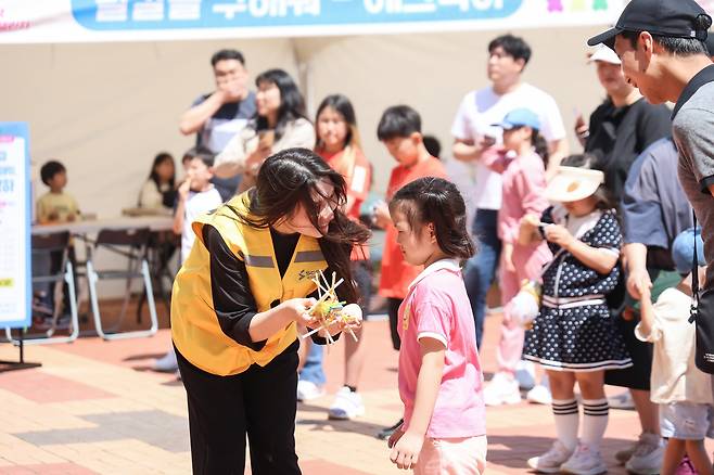 국립부산과학관 어린이날 과학체험행사 ‘뚝딱뚝딱 패밀리 챌린지’의 ‘만들어보자 뚝딱’ 부스에서 스태프가 어린이 참가자에게 체험 방법을 설명하고 있다. 사진=국립부산과학관 제공