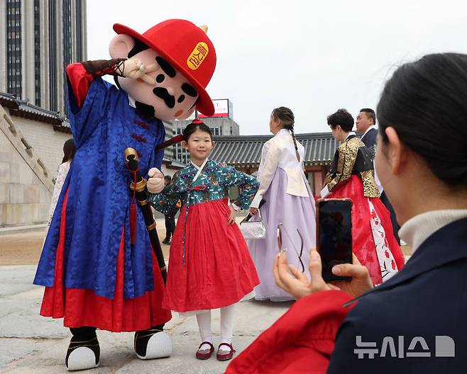 [서울=뉴시스] 조수정 기자 = 103주년 어린이날인 5일 서울 종로구 경복궁 광화문에서 한 어린이가 수문장 어린이날 특별행사로 열린 인형탈 파수의식을 관람한 뒤 함께 기념촬영 하고 있다. 2025.05.03. chocrystal@newsis.com