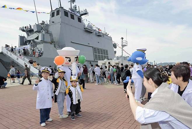 [부산=뉴시스] 어린이날을 맞아 해군작전사령부가 부대개방 및 함정공개행사를 개최한 5일 부산 남구 해군작전자 부산작전기지 천왕봉함(LST-Ⅱ) 앞에서 어린이들이 해군작전사 홍보캐릭터 '범이'와 해군 캐릭터 '이나비'와 함께 기념사진을 찍고 있다. (사진=해군작전사 제공) 2025.05.05. photo@newsis.com  *재판매 및 DB 금지