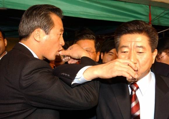 김문수 국민의힘 대선 후보와 한덕수 전 국무총리의 단일화 논의가 본격화할 예정인 가운데 방식으로는 ‘노무현·정몽준’ 모델이 주로 거론된다. 사진은 2002년 11월 15일 저녁 노무현(오른쪽) 새천년민주당 대선 후보와 정몽준 국민통합21 대선 후보가 국민여론조사에 의한 후보 단일화에 합의한 뒤 서울 여의도의 한 포장마차에서 소주잔으로 러브샷을 하는 모습. 서울신문 DB