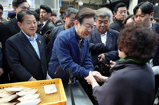 더불어민주당 이재명 대선 후보가 ‘골목골목 경청투어’ 접경지역 방문 이틀째인 5월2일 강원도 철원군 동송전통시장에서 떡집 상인과 만나 인사하고 있다. ⓒ연합뉴스