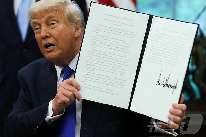 도널드 트럼프 미국 대통령이 5일(현지시간) 미국 워싱턴DC 백악관 오벌오피스에서 서명한 행정명령을 들어보이고 있다. ⓒ 로이터=뉴스1 ⓒ News1 류정민 특파원