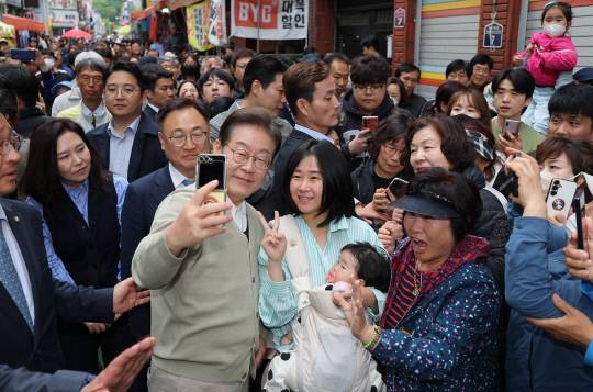 더불어민주당 이재명 대선 후보가 '골목골목 경청투어:국토종주편'에 나선 6일 충북 영동군 영동전통시장을 찾아 시민들과 기념촬영을 하고 있다. 연합뉴스