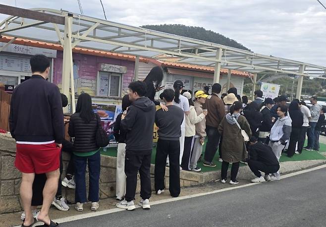 경남 통영 욕지도 고메원 점포에서 고구마도넛과 고구마라떼를 사려는 사람들이 길게 줄을 서서 기다리고 있다. 고메원 제공