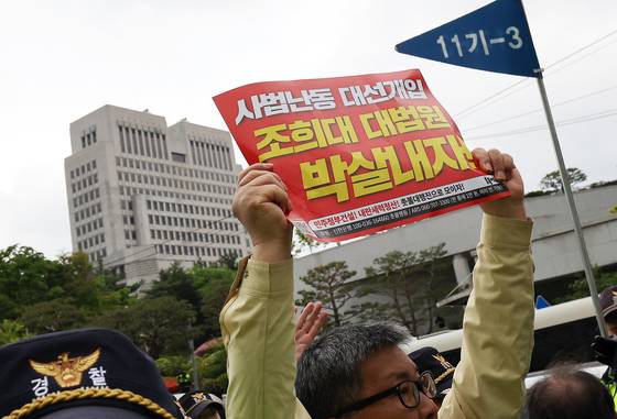 지난 3일 오후 서울 서초구 대법원 앞에서 열린 촛불행동 주최 제138차 촛불대행진에서 참가자들이 대법원 청사 건물을 향해 '조희대 대법원 박살내자'고 적힌 피켓을 들고 있다. 뉴스1