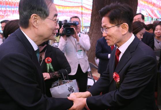 김문수(오른쪽) 국민의힘 대선 후보와 한덕수 무소속 대선 예비후보가 5일 서울 종로구 조계사에서 열린 불기 2569년 부처님오신날 봉축법요식을 마친 뒤 악수하고 있다. 연합뉴스