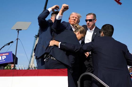 미국 대선 레이스가 한창이던 지난해 7월 13일(현지시간) 펜실베이니아주 버틀러 야외 유세장에서 귀에 총격을 입은 도널드 트럼프 당시 공화당 대선 후보가 오른손 주먹을 들어 보이며 “싸우자(Fight)”고 외치고 있다. 이 장면을 찍은 더그 밀스 뉴욕타임스(NYT) 사진 기자는 이를 포함해 일련의 트럼프 암살 미수 현장 사진으로 5일 퓰리처상 보도사진 부문 수상자로 선정됐다. 사진 퓰리처상 선정위원회 홈페이지