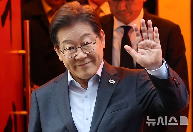 [서울=뉴시스] 조성우 기자 = 이재명 더불어민주당 대선후보가 1일 오후 서울 종로구의 한 포장마차에서 열린 비전형 노동자 간담회를 마치고 나오며 손을 들어 보이고 있다. 대법원 전원합의체는 이날 이 후보에게 무죄를 선고한 원심 판결을 파기하고 사건을 서울고법으로 돌려보냈다. (공동취재) 2025.05.01. photo@newsis.com