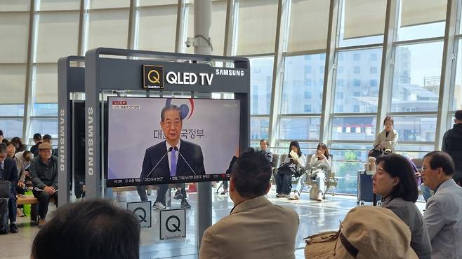 더불어민주당 호남권 경선이 열린 4월26일, 광주송정역 대합실에서 시민들이 대통령 권한대행 한덕수 국무총리에 대한 TV 뉴스 보도를 보고 있다.&nbsp;광주=변세현 기자