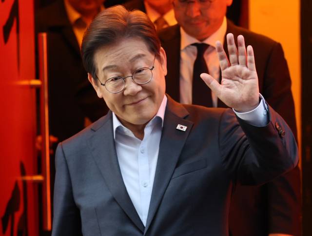 이재명 더불어민주당 대선 후보가 이달 1일 서울 종로구의 한 포차 식당에서 '당신의 하루를 만드는, 보이지 않는 영웅들'이란 주제로 열린 배달 라이더, 택배 기사 등 비(非)전형 노동자들과 간담회를 마친 뒤 이동하며 손인사를 하고 있다. 조태형 기자