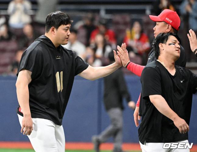 조상우(왼쪽)가 팀 승리 후 이범호 감독과 하이파이브를 하고 있다.