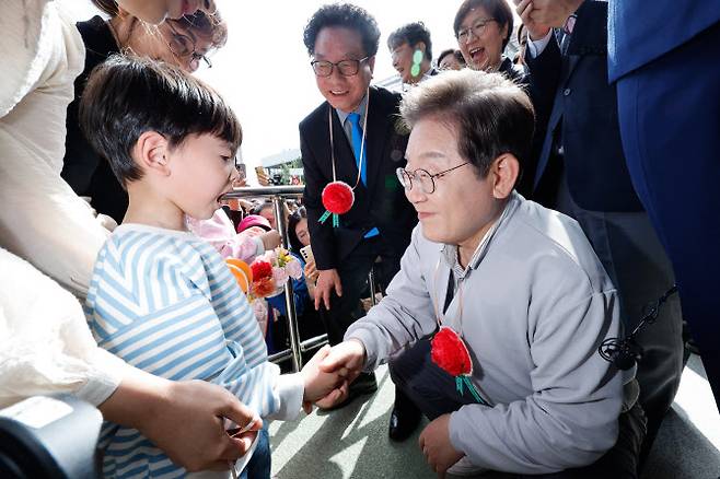 이재명 더불어민주당 대통령 후보가 2차 골목골목 경청투어 마지막 날인 7일 오후 전북 익산시 대한노인회 익산지회에서 열린 임원과의 간담회에 참석하기 전 어린이로부터 카네이션 콕걸이를 선물받고 있다.(사진=뉴스1)
