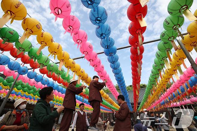 불기 2569년 부처님 오신 날이던 지난 5일 오전 대구 동구 동화사를 찾은 불자들이 대웅전 앞 봉축 연등에 소원지를 매달고 있다. 2025.5.5/뉴스1 ⓒ News1 공정식 기자