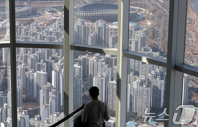 13일 서울 송파구 롯데월드타워 서울스카이를 찾은 관람객이 서울 송파구 잠실 아파트단지를 바라보고 있다.  2025.2.13/뉴스1 ⓒ News1 박세연 기자