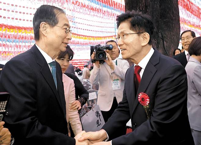 조계사에서 손은 잡았지만… ‐ 김문수(오른쪽) 국민의힘 대선 후보와 한덕수 무소속 대선 예비후보가 5일 서울 종로구 조계사에서 열린 부처님오신날 봉축법요식에서 악수하고 있다. /연합뉴스
